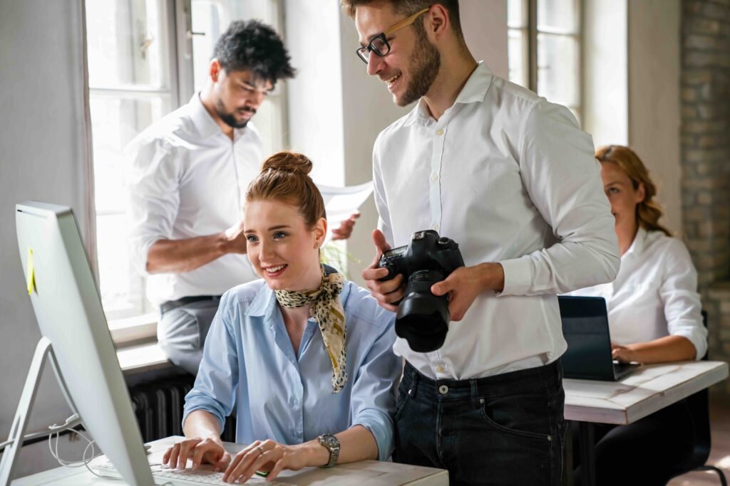 Close up of creative startup young business people with digital camera working together at designer agency in office